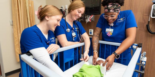 Nurses around crib